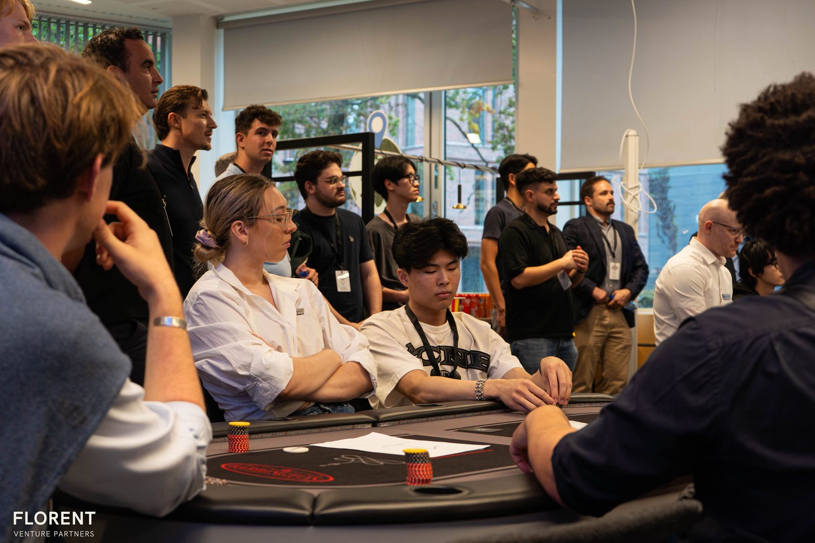 Competitors and guests gathered around a poker table at the finals